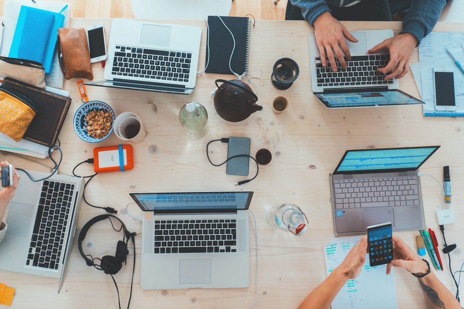 Work table covered with laptops and electronic devices